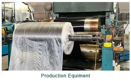 Close-up of heavy-duty drum-type curing press machinery processing continuous rubber sheets.