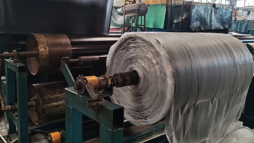 High-volume production of commercial-grade SBR rubber sheet rolls and anti-slip ribbed matting, ready for international container shipment. Bulk rolls of black SBR rubber sheets and patterned floor mats manufactured in factory workshop
